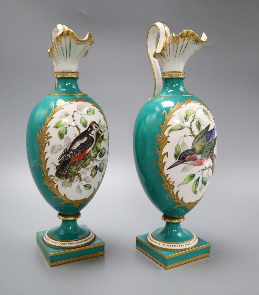 A pair of Coalport green glazed ewers, hand painted birds to the body, height 27cm